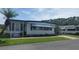 Inviting single-story home featuring a well-maintained lawn and convenient carport space at 117 Hibiscus Way, Leesburg, FL 34748