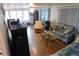 Cozy living room with wood floors, bright windows, and comfortable seating arrangement at 117 Hibiscus Way, Leesburg, FL 34748