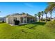 A spacious backyard with a screened-in lanai, pergola, and lush green grass at 1313 La Estrellita Way, The Villages, FL 32162