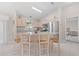 Kitchen with stainless steel appliances, island with bar seating, and tile floors at 1313 La Estrellita Way, The Villages, FL 32162