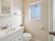 Bathroom with a white vanity, toilet, and a window, all illuminated by natural light at 1907 E Chapel Dr, Deltona, FL 32738