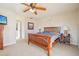 Bedroom with carpet, wooden furniture, ceiling fan, and a hallway leading to other rooms at 1907 E Chapel Dr, Deltona, FL 32738
