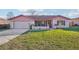 Charming single-story home with a brick facade, a well-manicured lawn, and an attached garage at 1907 E Chapel Dr, Deltona, FL 32738