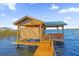 Covered boat dock featuring a lift and spacious deck at 30303 Island Club Dr, Tavares, FL 32778