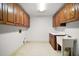 Bright laundry room with ample cabinetry and a utility sink at 34620 Galla Rd, Fruitland Park, FL 34731