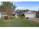 Single-story home with solar panels, landscaped yard, and two-car garage at 3550 Auburndale Ave, The Villages, FL 32162