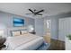 Relaxing bedroom with a ceiling fan, ensuite bathroom access, light colored walls, and beach themed accents at 3550 Auburndale Ave, The Villages, FL 32162