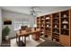 Bright and functional home office featuring built-in bookshelves and a spacious desk, ideal for remote work at 3550 Auburndale Ave, The Villages, FL 32162