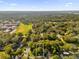 Aerial view of a residential area surrounded by lush trees, featuring a large field and school at Tbd E Jackson Ave, Mount Dora, FL 32757