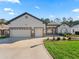 House exterior with three-car garage and landscaping at 10994 Se 168Th Loop, Summerfield, FL 34491