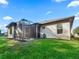 Exterior view of house with screened porch and grassy yard at 10994 Se 168Th Loop, Summerfield, FL 34491