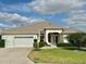 Inviting single-story home with a well-kept lawn, a two-car garage, and a welcoming front entrance at 1270 Addison Ave, The Villages, FL 32162