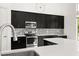 Modern kitchen featuring sleek black cabinets, stainless steel appliances, and a stylish backsplash at 39539 Harbor Hills Blvd, Lady Lake, FL 32159