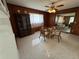 Dining room features wood-paneled walls, a ceiling fan and light fixture with a view into the living room at 4060 Lake Marianna Dr, Winter Haven, FL 33881