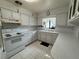 Bright kitchen featuring white cabinets, countertops, a window over the sink, and marble-patterned tile flooring at 4060 Lake Marianna Dr, Winter Haven, FL 33881