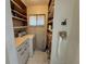 Compact laundry area with a vintage washer, overhead shelving, and white patterned flooring with natural light at 4060 Lake Marianna Dr, Winter Haven, FL 33881