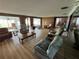 Spacious living room with wood paneled walls, an expansive layout and view to the backyard and lake at 4060 Lake Marianna Dr, Winter Haven, FL 33881