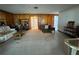 Comfortable living room featuring paneled walls, carpet, and a bright, airy atmosphere at 4060 Lake Marianna Dr, Winter Haven, FL 33881
