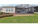 Large backyard with lush landscaping and screened patio at 537 Narrow View Ln, Groveland, FL 34736