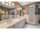 Large bathroom featuring dual sinks, shower, and a vanity with ample storage, plus unique wall coverings at 5415 Banana Point Dr, Okahumpka, FL 34762