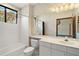 Bathroom featuring a white tiled shower-tub, vanity with storage, and a large mirror, plus decorative wallpaper at 5415 Banana Point Dr, Okahumpka, FL 34762