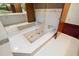 Bathroom featuring a luxurious soaking tub, tiled flooring, and mirrored wall to enhance spaciousness at 5415 Banana Point Dr, Okahumpka, FL 34762