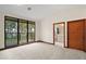 Bright bedroom featuring a sliding glass door leading to a balcony with beautiful views, next to en-suite bathroom at 5415 Banana Point Dr, Okahumpka, FL 34762
