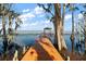 Long wooden dock with covered gazebo extends into a calm lake, framed by cypress trees at 5415 Banana Point Dr, Okahumpka, FL 34762