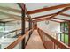 Hallway with wood beams, railings and large windows, offers scenic views of the surrounding landscape at 5415 Banana Point Dr, Okahumpka, FL 34762