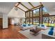 Bright living room featuring vaulted ceilings, exposed beams, and walls of windows at 5415 Banana Point Dr, Okahumpka, FL 34762