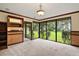 Open living area with built-in shelving and large windows offering beautiful views of the outdoor greenery at 5415 Banana Point Dr, Okahumpka, FL 34762
