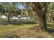 Picturesque property entrance with mature trees lining a driveway and wooden fence at 5415 Banana Point Dr, Okahumpka, FL 34762