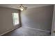 Cozy bedroom with neutral walls, a ceiling fan, and a window providing natural light at 702 S Grand Hwy, Clermont, FL 34711