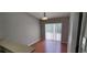 Sun-drenched dining area features sliding glass doors, wood-look flooring, and neutral paint at 702 S Grand Hwy, Clermont, FL 34711