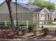 Charming townhome featuring a well-maintained landscape and a classic white picket fence at 702 S Grand Hwy, Clermont, FL 34711