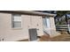Here is an image of the back of the property showcasing the HVAC, electric meter, and small set of stairs at 702 S Grand Hwy, Clermont, FL 34711
