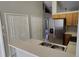 View of kitchen features stainless steel refrigerator, lots of storage, and a view of the living area at 702 S Grand Hwy, Clermont, FL 34711