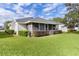 Well-maintained backyard featuring a screened-in porch and manicured landscaping and mature plantings at 950 Beaver Run, Tavares, FL 32778