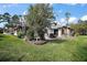 Beautiful backyard with a brick paved patio, outdoor dining set, and lush green lawn at 102 Cedar Way, Yalaha, FL 34797