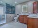 Bathroom with marble shower and modern cabinets at 102 Cedar Way, Yalaha, FL 34797
