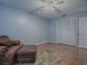Bedroom featuring light blue walls, laminate floors, ceiling fan, closet, and leather chair with ottoman at 102 Cedar Way, Yalaha, FL 34797