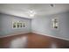 Bright bedroom featuring hardwood floors, light-blue walls, ceiling fan, and shuttered windows at 102 Cedar Way, Yalaha, FL 34797