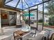Screened patio with tile flooring, comfortable seating, and views of the backyard at 102 Cedar Way, Yalaha, FL 34797