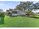 Well manicured front yard featuring a home with screened in porch, mature plants, and green grass at 11584 Se 175Th St, Summerfield, FL 34491