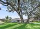 Inviting single-story home shaded by a large, mature tree, featuring a well-kept lawn and landscaping and patterned driveway at 11584 Se 175Th St, Summerfield, FL 34491