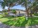 Charming single-story home featuring a well-manicured lawn and mature trees, creating a welcoming curb appeal at 11584 Se 175Th St, Summerfield, FL 34491