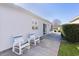 White vinyl house with sliding glass door to a back patio, two chairs, and grassy yard at 1639 Campos Dr, The Villages, FL 32162