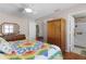 Bedroom showcasing hardwood floors, a wooden armoire, and access to an ensuite bathroom at 1639 Campos Dr, The Villages, FL 32162