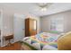 Bright bedroom with a colorful quilt, wood floors, and a built-in closet providing ample storage at 1639 Campos Dr, The Villages, FL 32162
