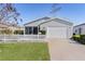 Gray house with white picket fence and attached garage at 1639 Campos Dr, The Villages, FL 32162